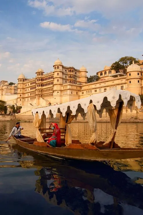 Travelers enjoying a stunning view of Udaipur's royal palaces and Lake Pichola